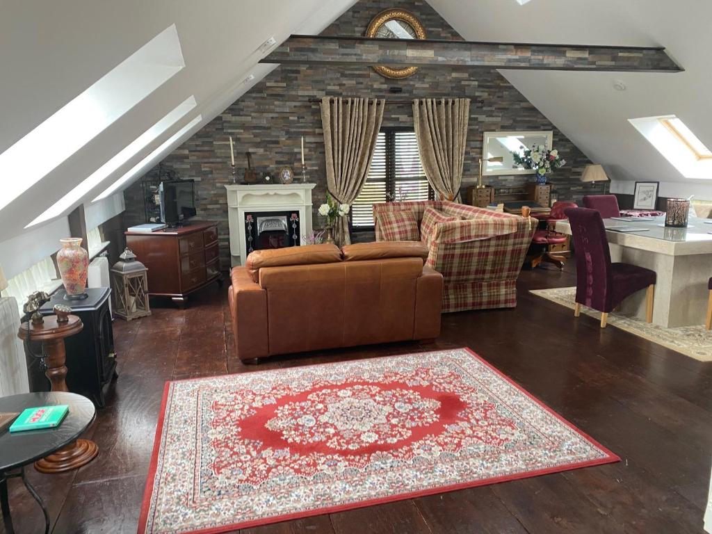 a living room with a brown couch and a fireplace at Tides Apartments Liscannor in Liscannor