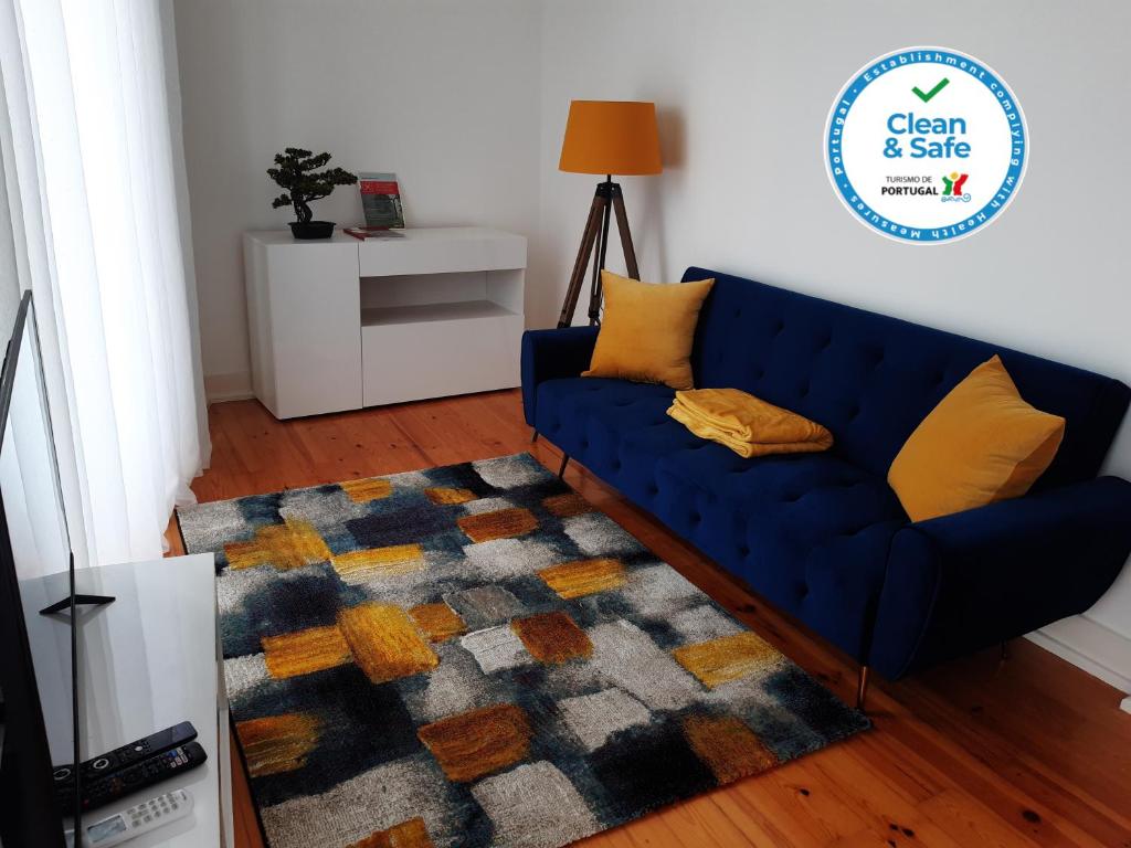 Sofá azul en la sala de estar con alfombra en Sintra Lux Home en Sintra