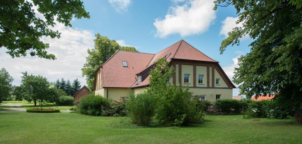 uma casa com um telhado vermelho num jardim verde em Ostsee-Landhaus em Rerik