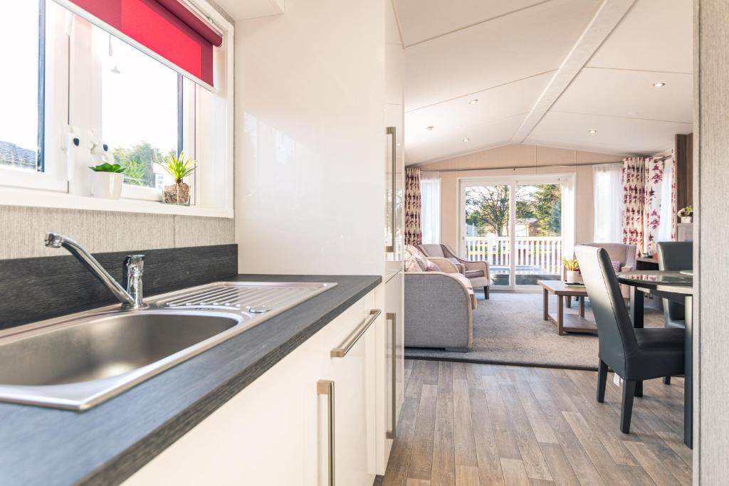 uma cozinha com um lavatório e uma sala de estar em Lakeshore Lodge with Hot Tub em Pocklington