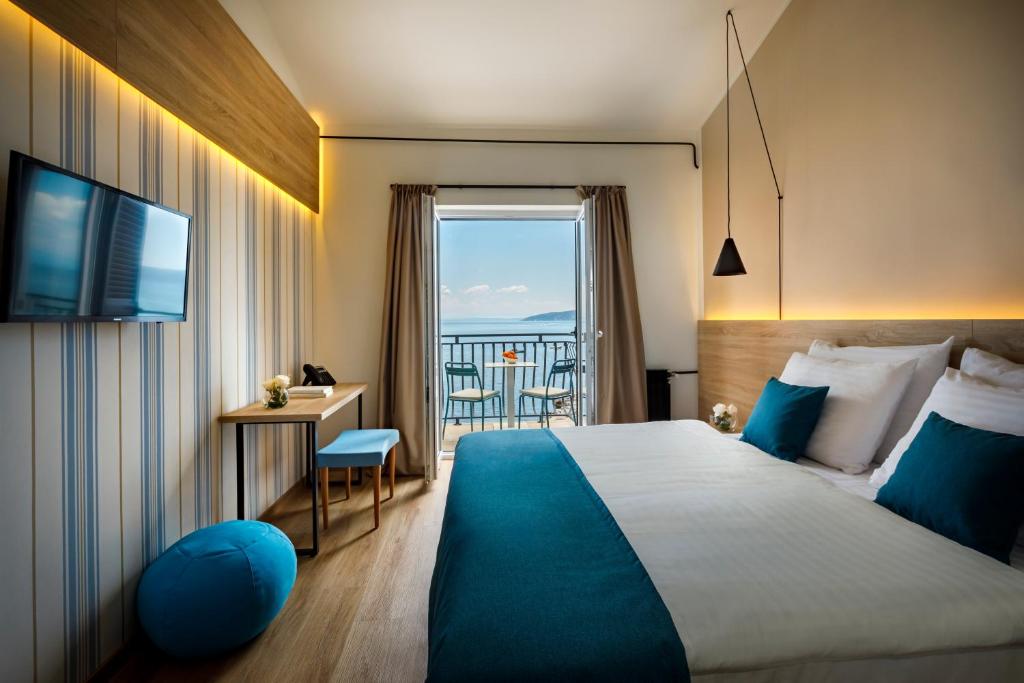 a hotel room with a large bed and a balcony at Hotel Mediteran - Liburnia in Mošćenička Draga
