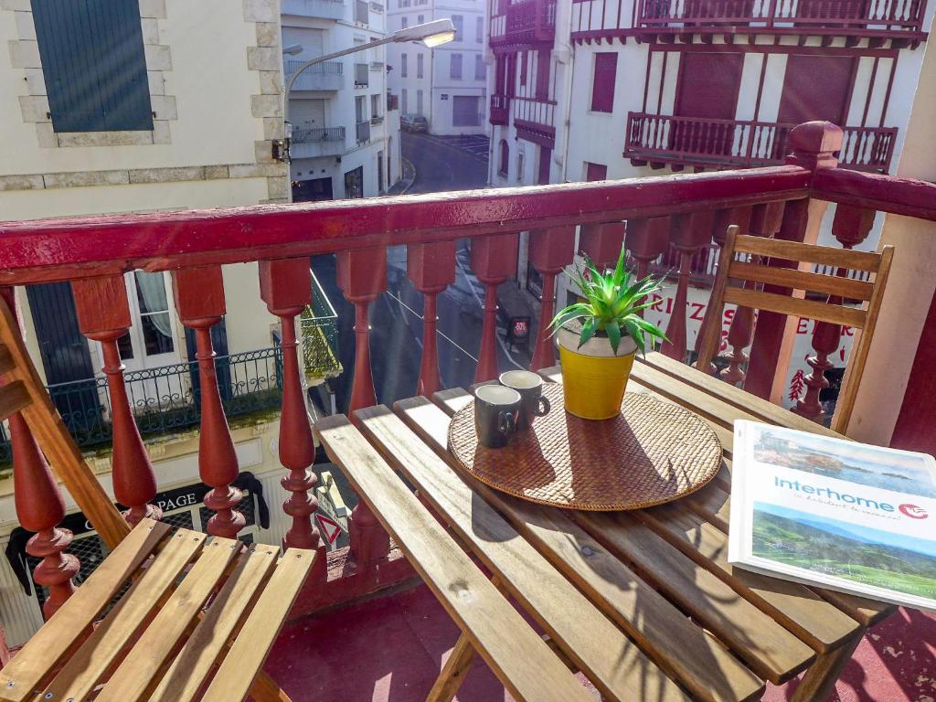 una mesa de madera con una planta en el balcón en Apartment Goélands by Interhome, en Biarritz