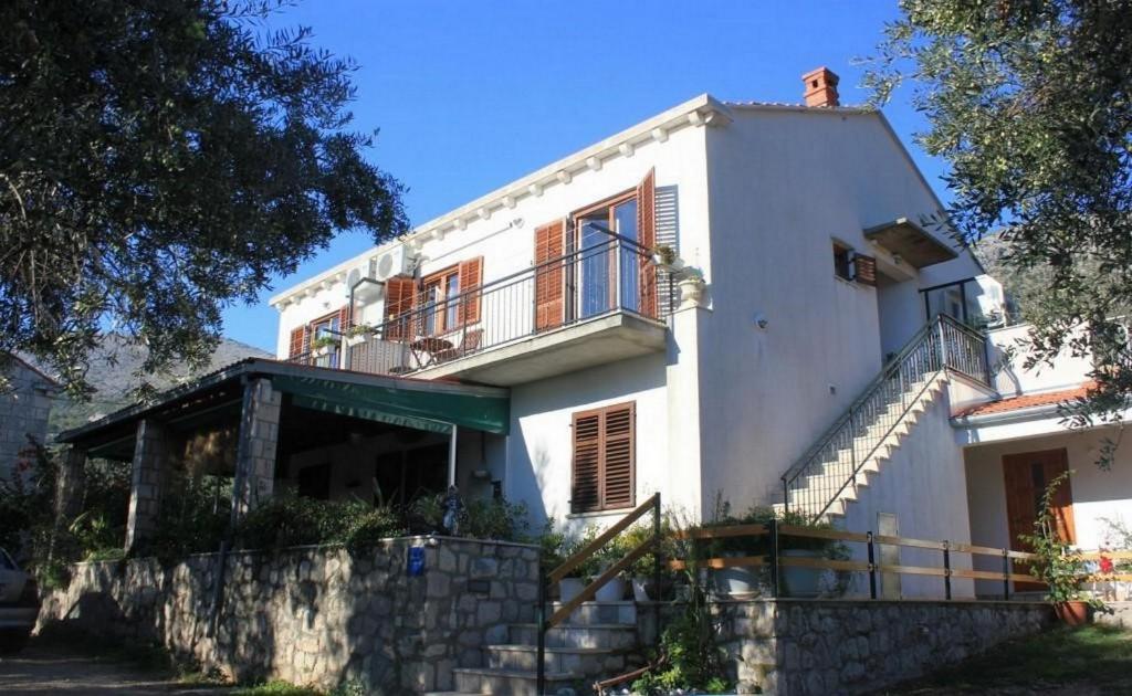 Casa blanca con balcón en la parte superior. en Villa Ro-Ela en Trsteno