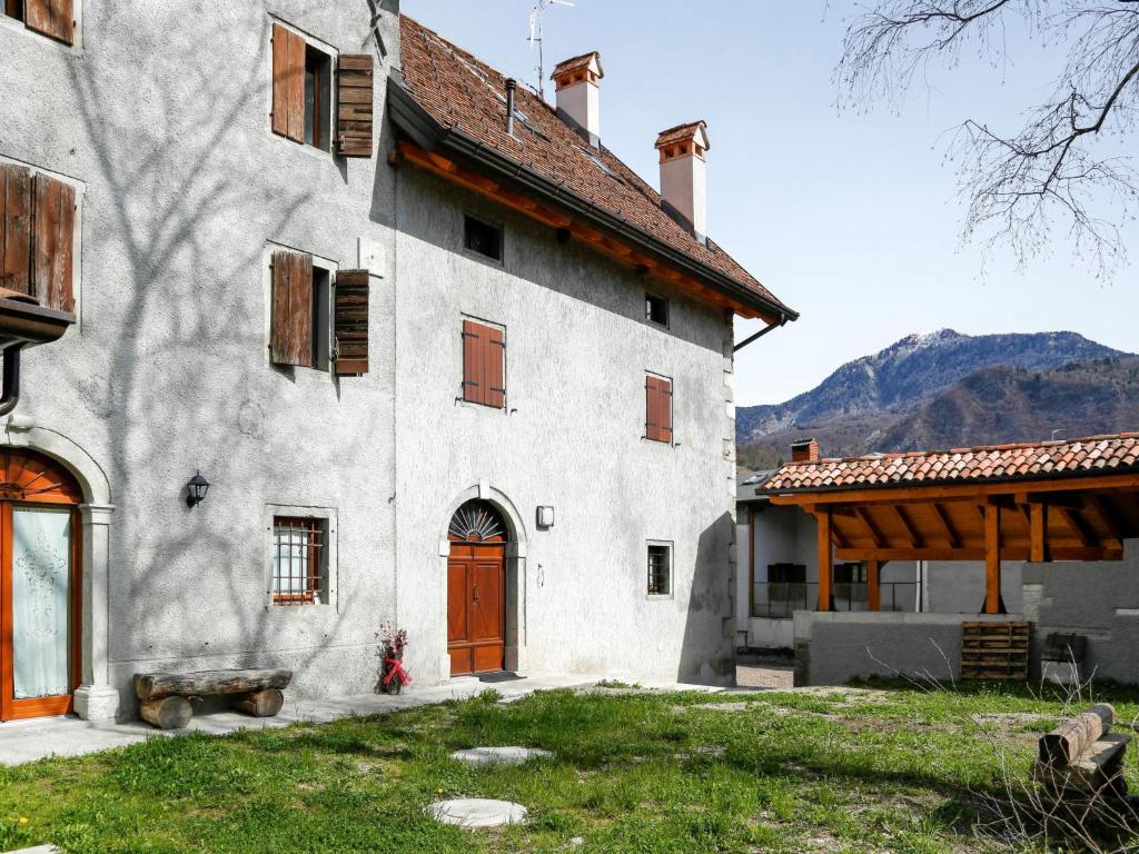 a large white building with a red door at Apartment Cjase da Maestre-2 by Interhome in Raveo