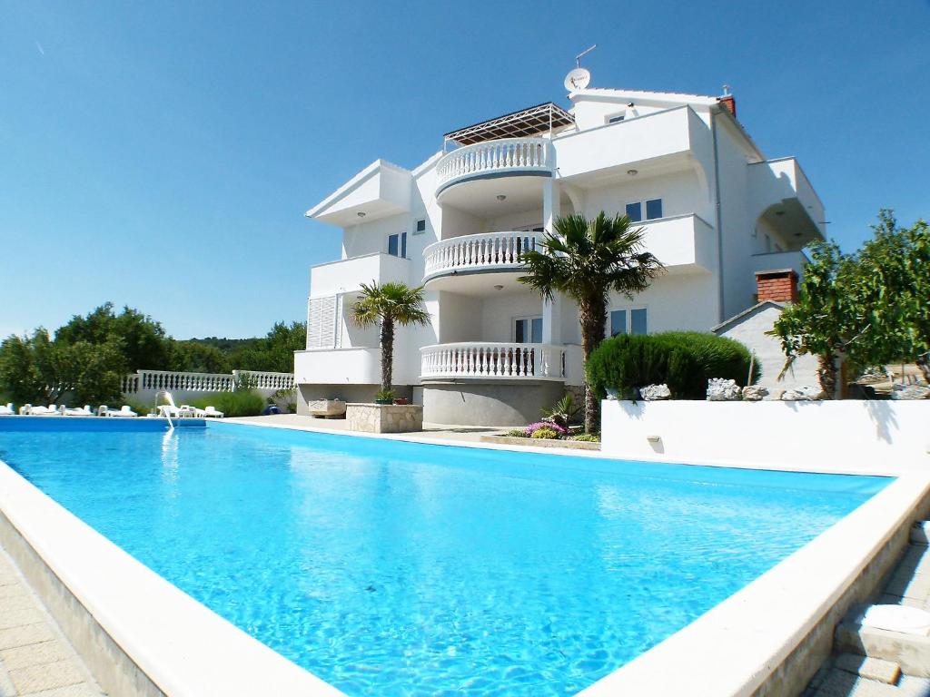 un bâtiment avec une piscine en face d'un bâtiment dans l'établissement Apartment Rina-4 by Interhome, à Vodice