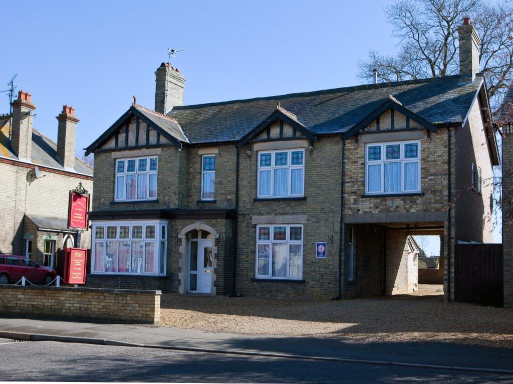 a large brick house with a garage on a street at The Causeway Guest House in March