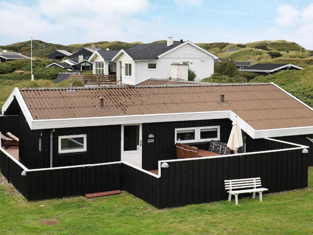 a black and white house with a roof at Holiday home Blokhus X in Blokhus