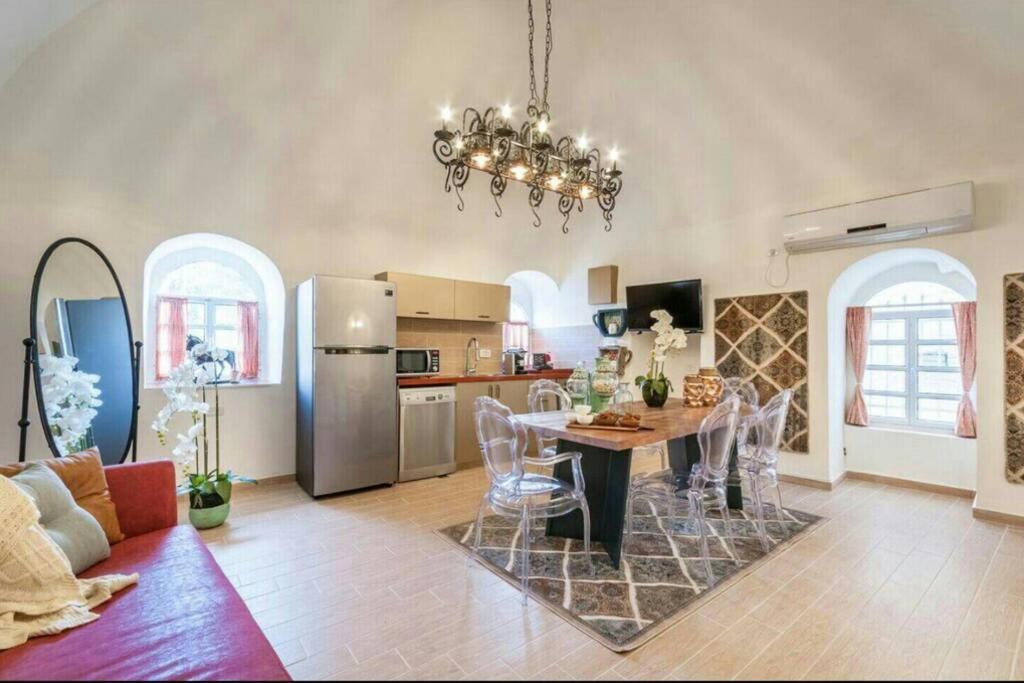een keuken en een woonkamer met een tafel en een koelkast bij Private House 5 BDR In Mamilla up to 12 People ! in Jeruzalem