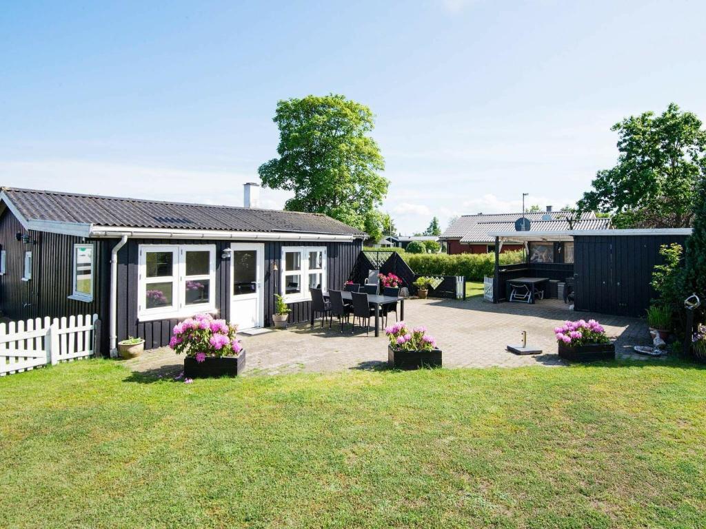 um quintal com uma casa e um pátio com flores em Holiday Home Diernæs II em Diernæs