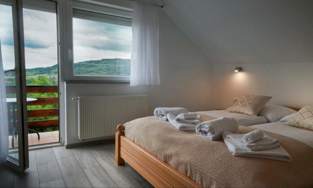 a bedroom with two beds and a large window at Apartment Josipa in Seliste Dreznicko