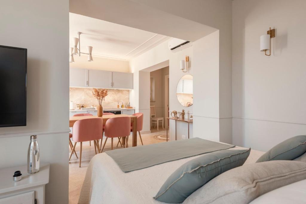 sypialnia z 2 łóżkami i kuchnia ze stołem w obiekcie Antea Apartments w mieście San Vincenzo