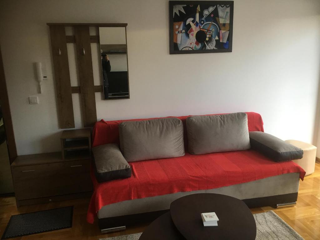 um sofá vermelho numa sala de estar com um espelho em Apartman Andjelina Lux Zlatibor em Zlatibor