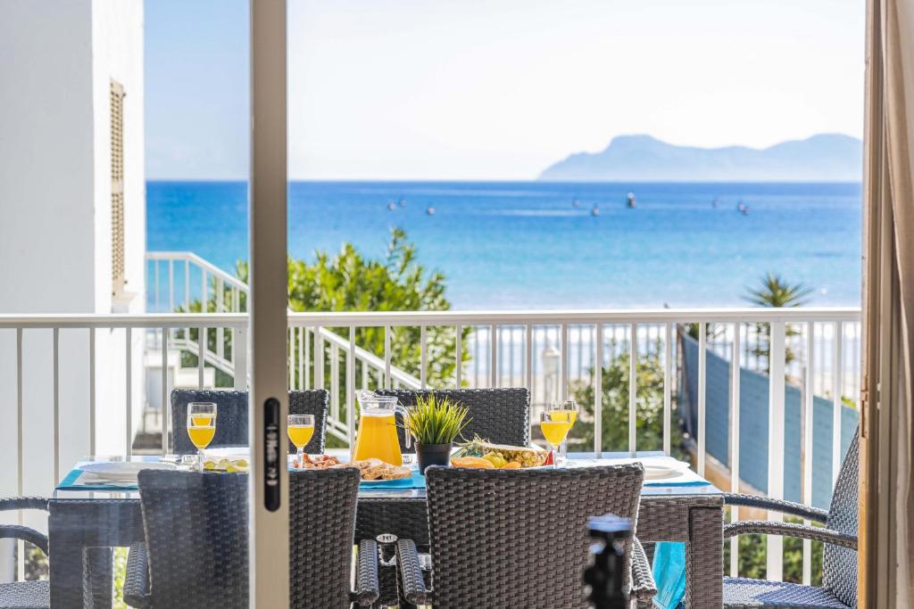 a table on a balcony with a view of the ocean at Apartamento Vista Brava in Playa de Muro