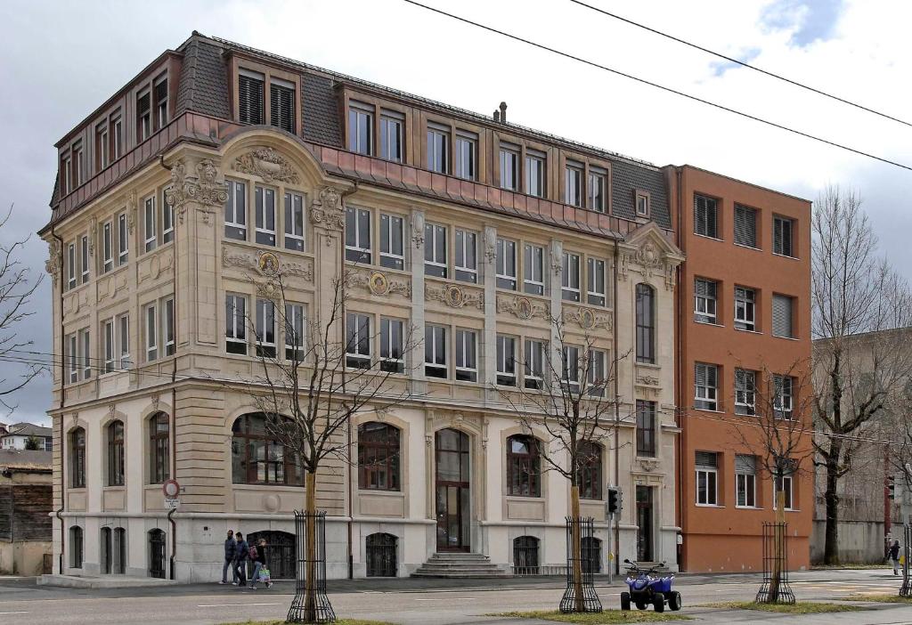 ein großes Gebäude an der Ecke einer Straße in der Unterkunft HéberGement du POD in La Chaux-de-Fonds