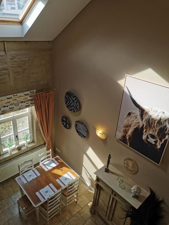 een kamer met een tafel en een foto van een koe aan de muur bij Cépage de la Tourelle in Ways