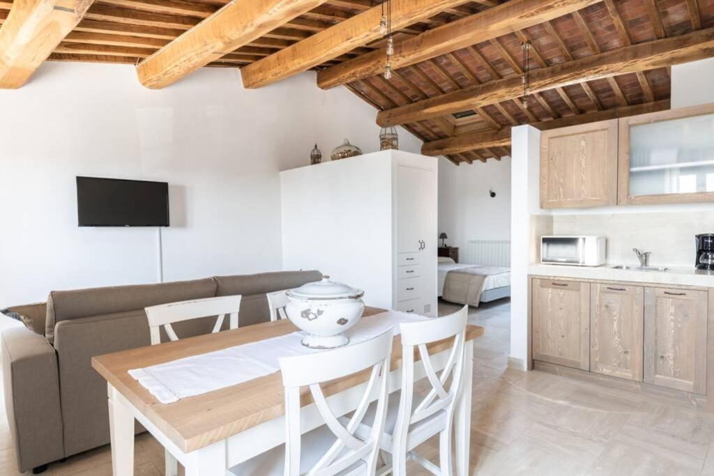 a kitchen and living room with a table and chairs at La Piazza - Appartamento con vista in Sinalunga