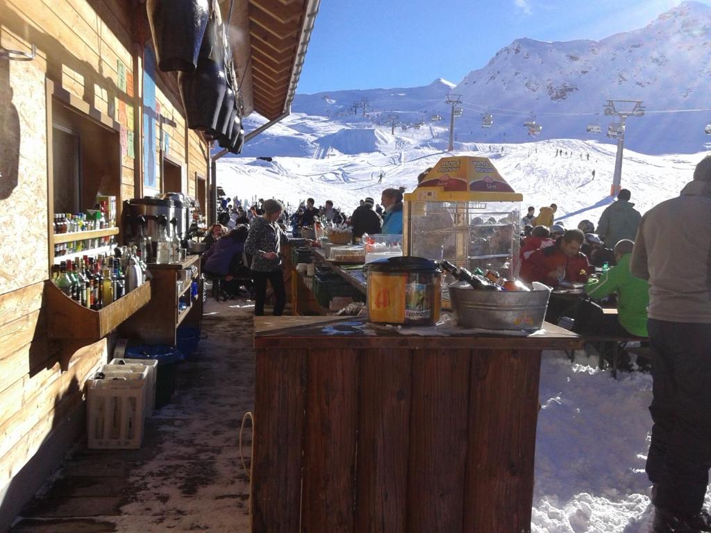 a group of people sitting at a bar in the snow at Obere Frutt 9 in Frutt