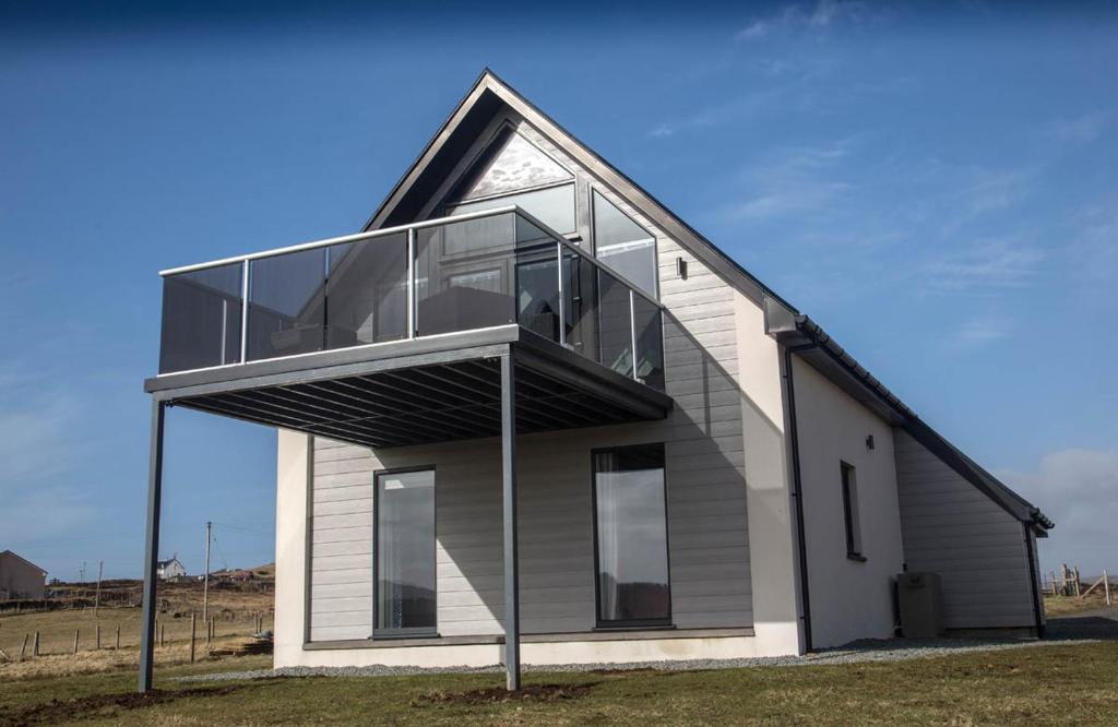 ein Haus mit einem großen Glasfenster an der Seite in der Unterkunft Oor Neuk in Tole