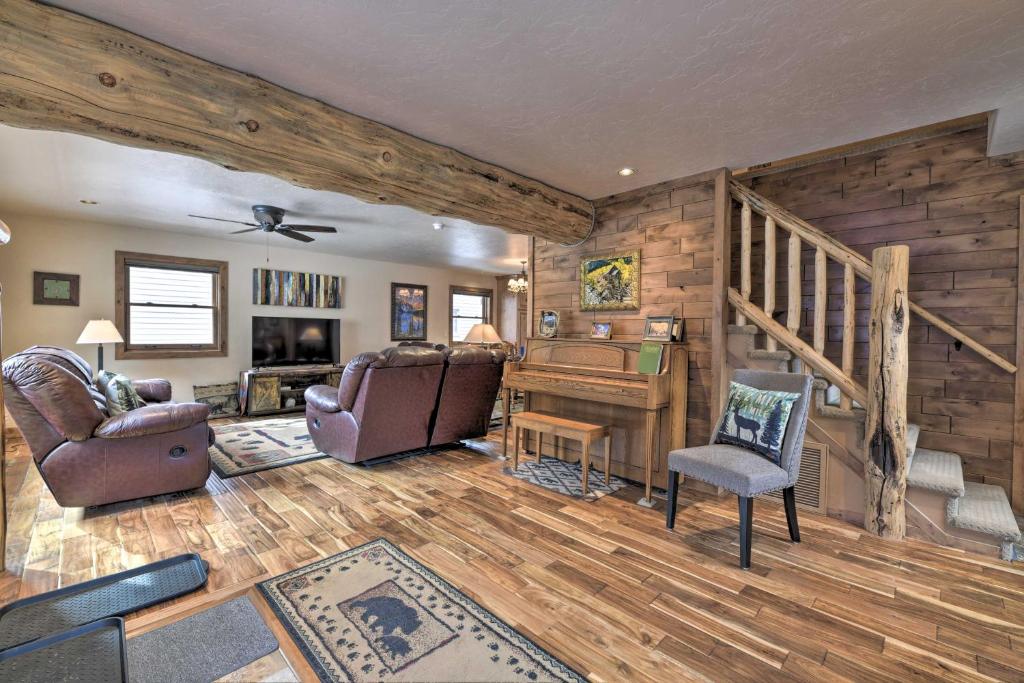 a living room with a staircase and a piano at Updated Mtn Home with Deck on Uncompahgre River in Ouray