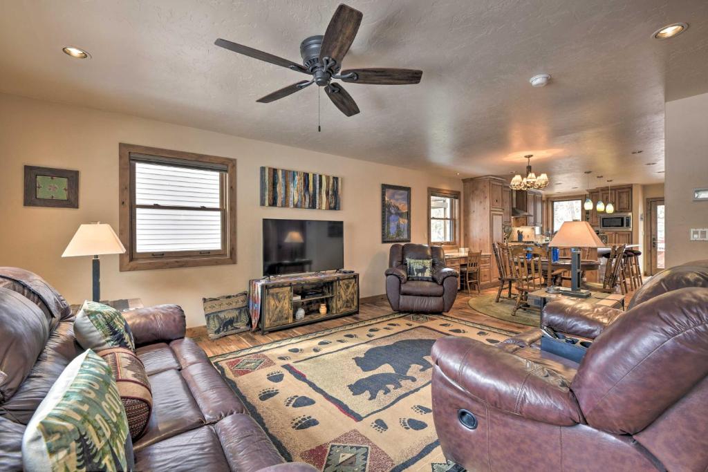 a living room with leather furniture and a ceiling fan at Updated Mtn Home with Deck on Uncompahgre River in Ouray