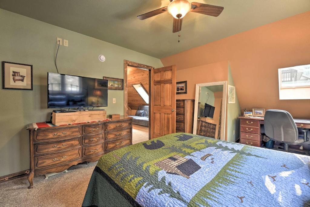 a bedroom with a bed and a flat screen tv at Updated Mtn Home with Deck on Uncompahgre River in Ouray