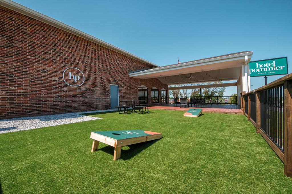 a yard with a ping pong table in front of a building at Hotel Pommier Indianola in Indianola