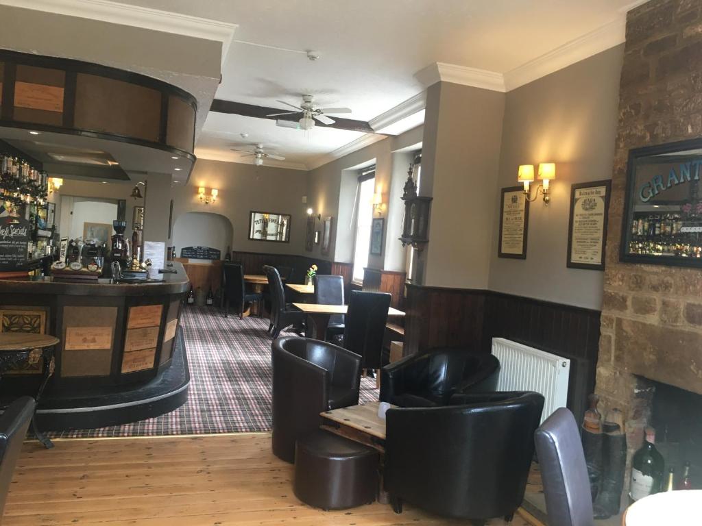 um restaurante com mesas e cadeiras e um bar em The White Hart Hotel em Martock