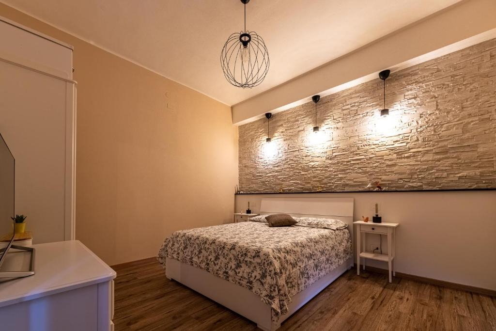 1 dormitorio con cama y pared de ladrillo en San Miniato - Terrazza panoramica in centro storico en San Miniato