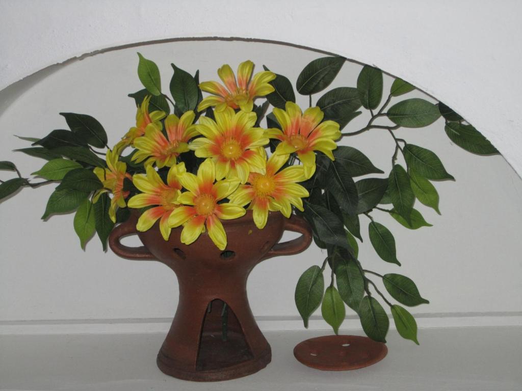 a vase with yellow and orange flowers in it at Casa da Avó in Redondo