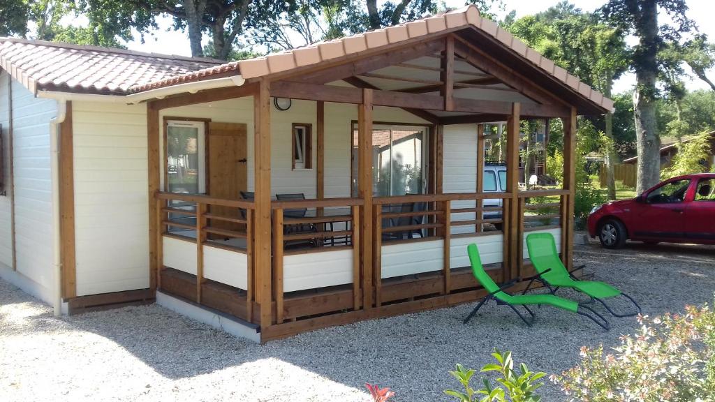 uma cabina com toldo e uma cadeira verde em chalet avec piscine em Azur