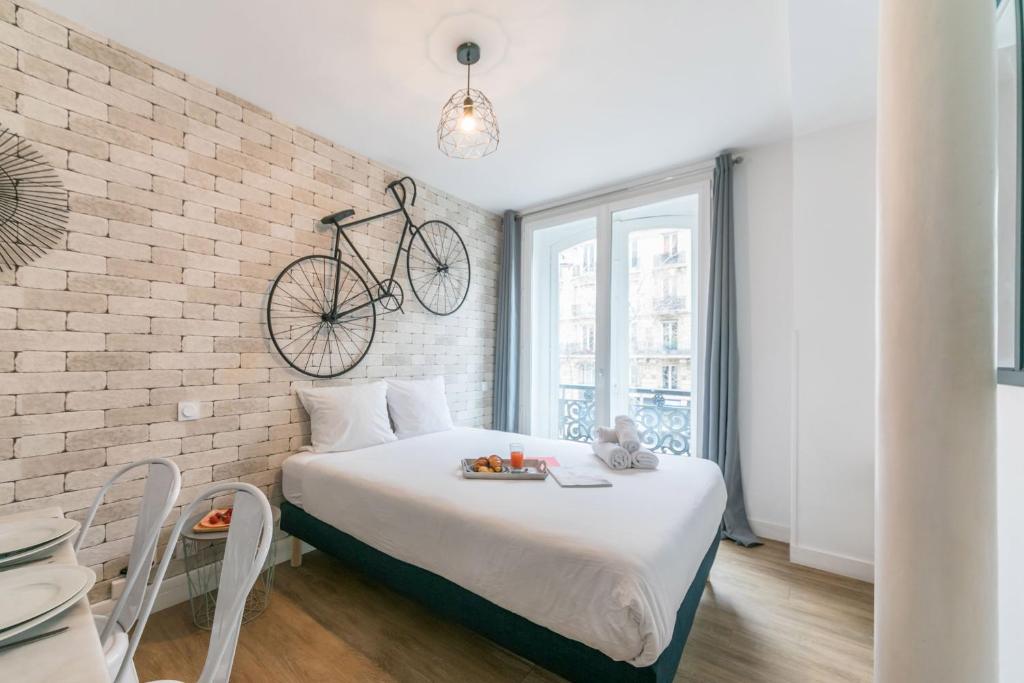 una camera da letto con un letto con una bicicletta appesa al muro di Apartments WS St Germain - Quartier Latin a Parigi