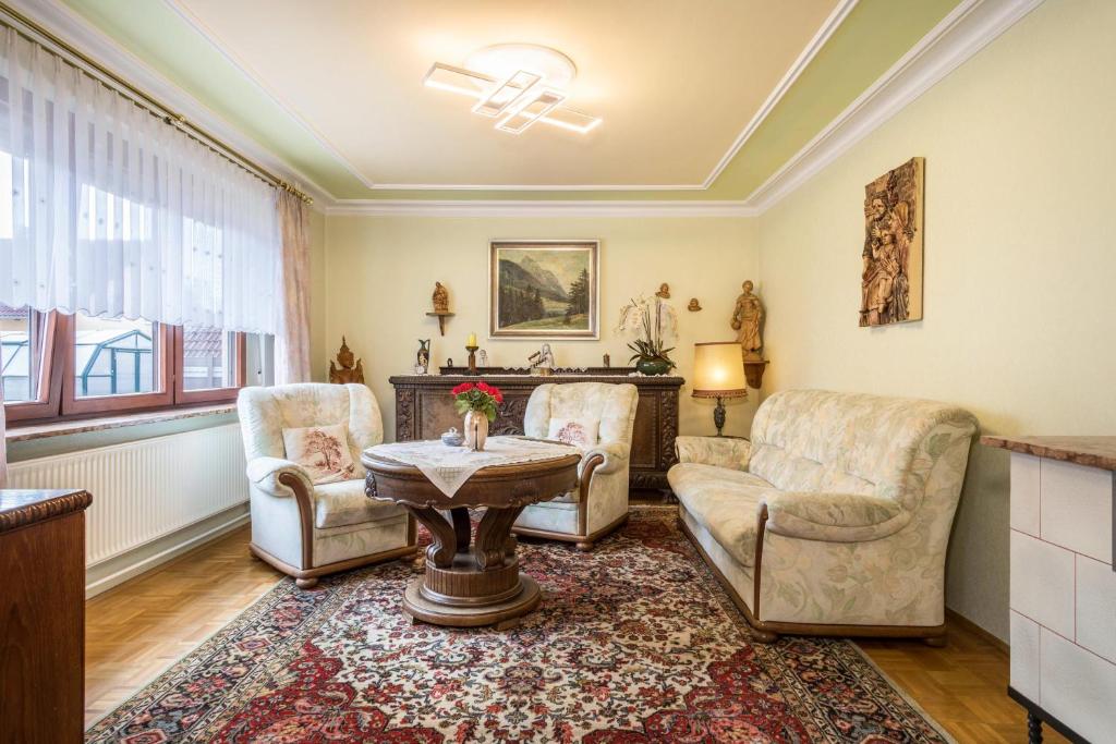 een woonkamer met 2 stoelen en een tafel bij Ferienwohnung Gaissmaier in Eriskirch