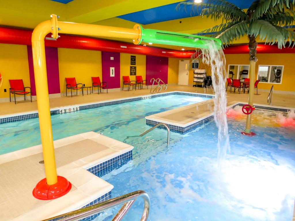 a swimming pool with a waterfall in a hotel at Comfort Suites Regina in Regina