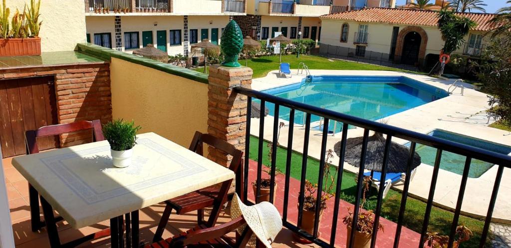 托雷莫利諾斯的住宿－Apartamento Blancomar，一个带桌子和游泳池的阳台
