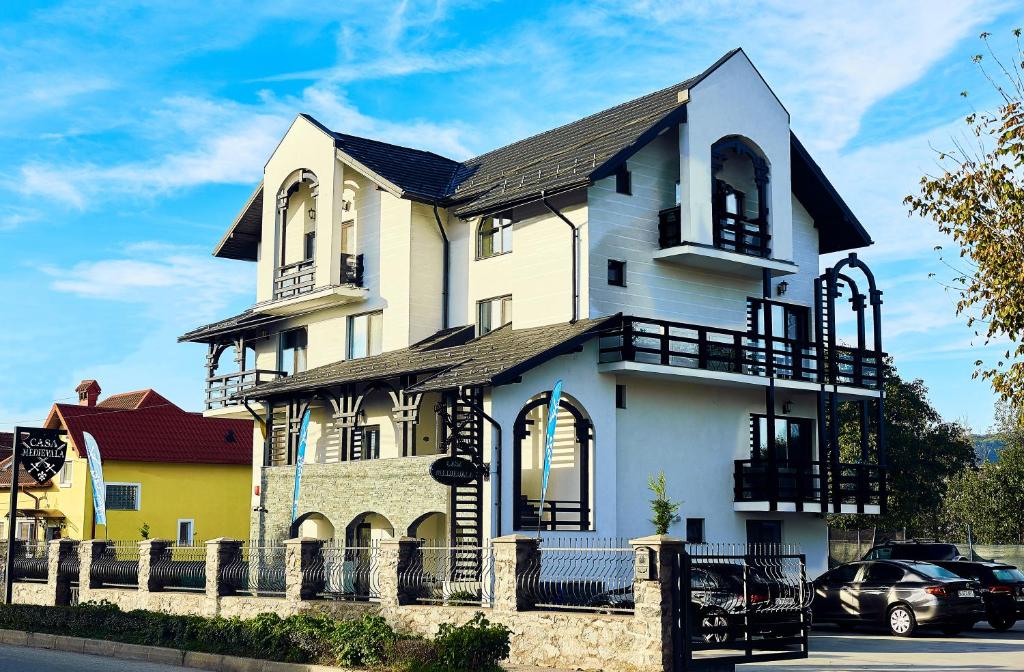 a large white house with a black roof at Boutique Hotel Casa Medievala in Curtea de Argeş