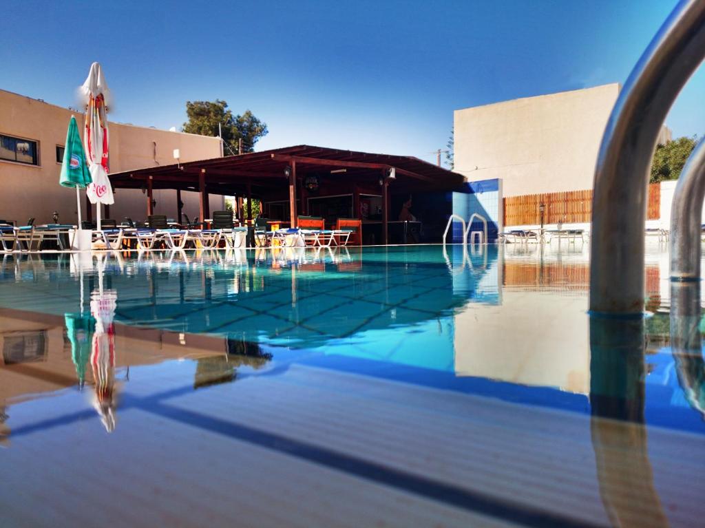 una piscina con mesas y sillas y un edificio en Florea Hotel Apartments, en Ayia Napa