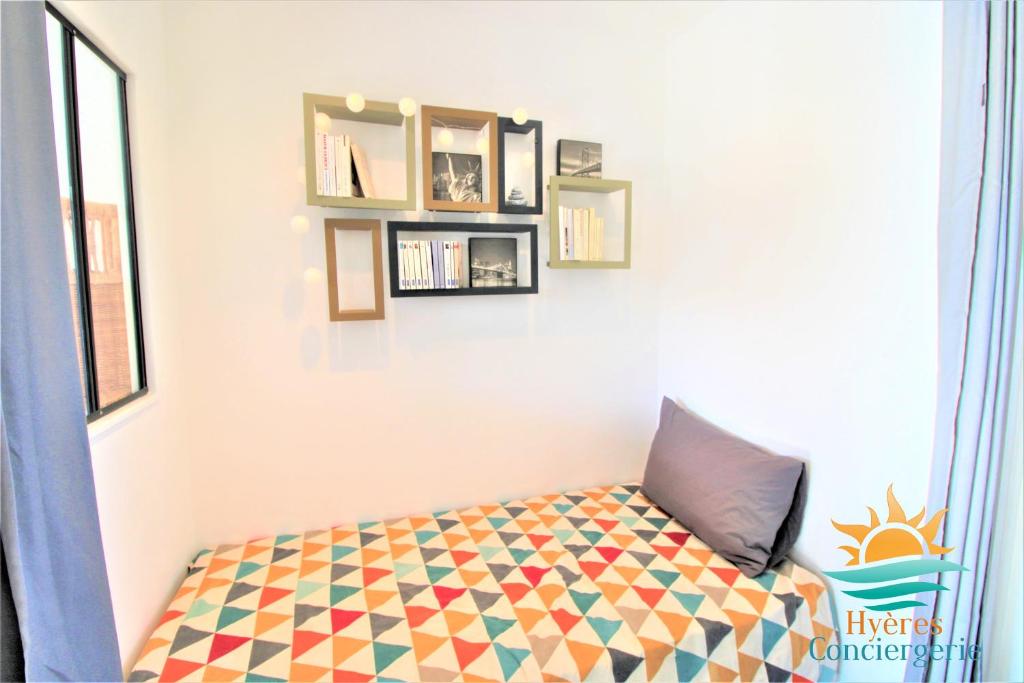 ein Zimmer mit einem Bett mit einem Kissen darauf in der Unterkunft Hyères-plage Studio cabine-L'ayguade BY HC in Hyères