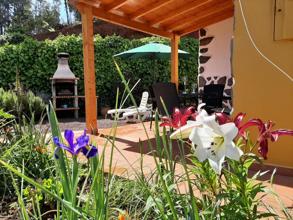 a garden with flowers and a pergola at Barrancolaurel in Moya