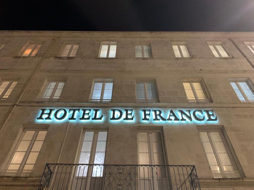 a hotel de france sign on the side of a building at Hotel de France Citotel in Rochefort