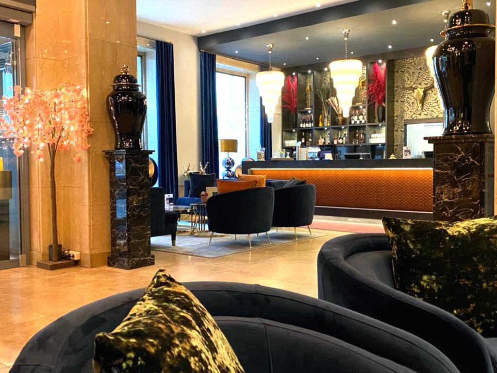 a lobby with a couch and a bar in the background at Boutique Hotel Germania in Munich