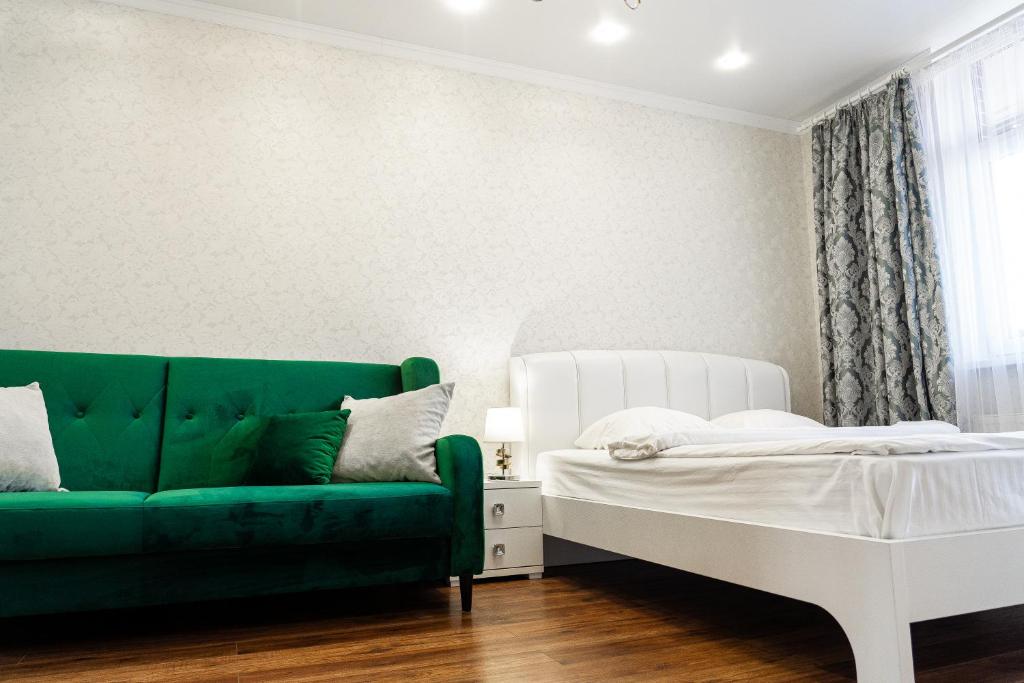カリーニングラードにあるApartment Elegantのリビングルーム(緑のソファ、ベッド付)