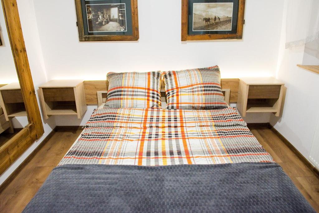 a bed with a plaid blanket on it in a room at GOLD-BOX in Nowy Targ