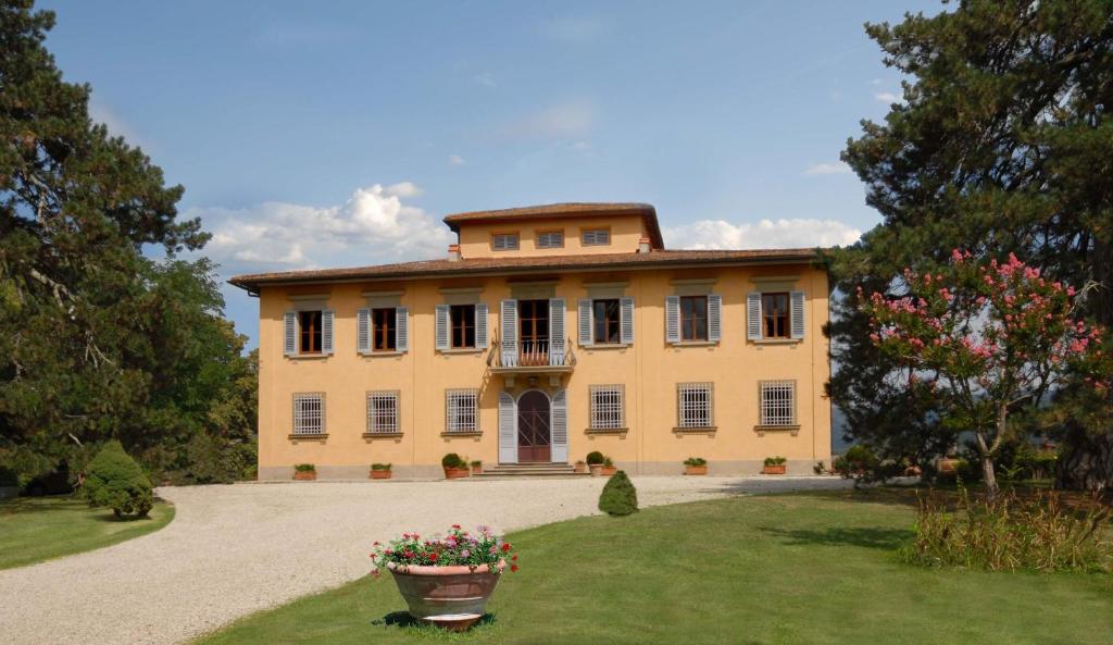 a large yellow house with a large yard at Villa Di Collina in Vicchio