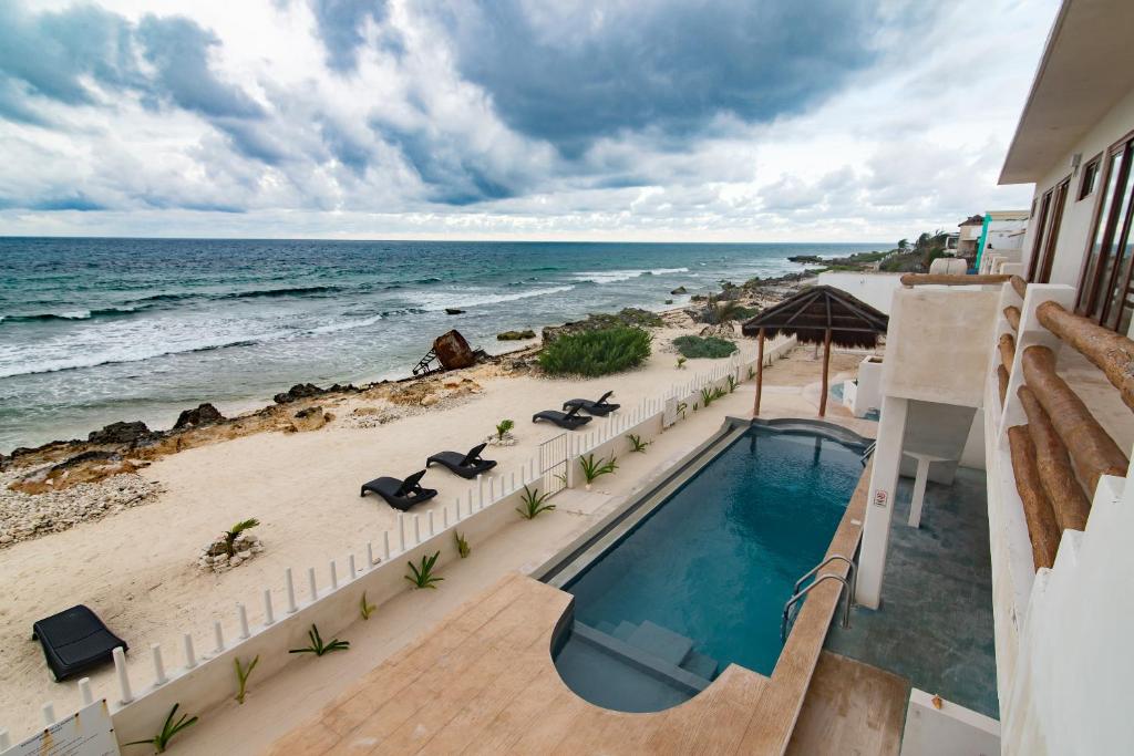 uma vista para uma piscina e para a praia em Villas Najo' Isla Mujeres. em Ilha das Mulheres