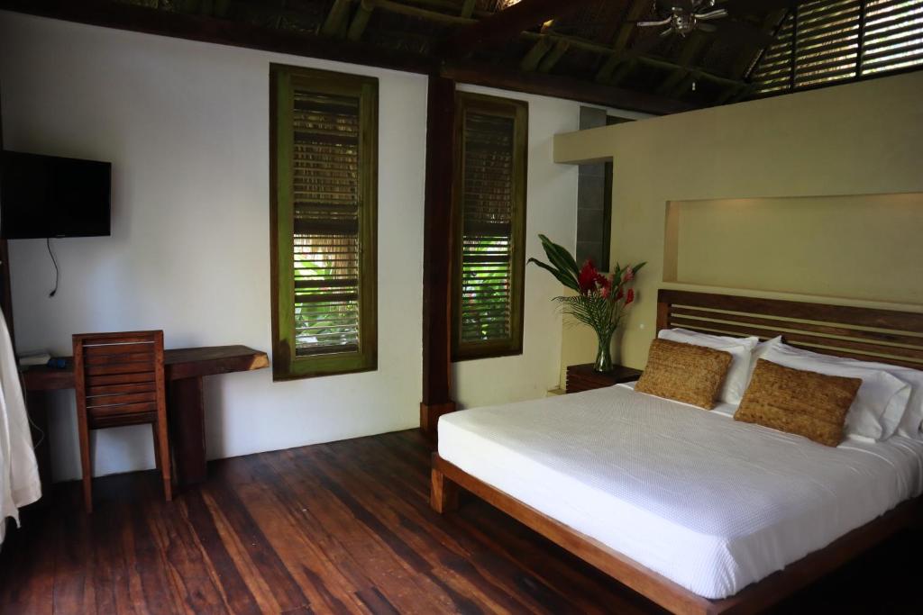 洛斯纳兰霍斯Casa Bambu Tayrona, Los Naranjos的带床、书桌和窗户的卧室