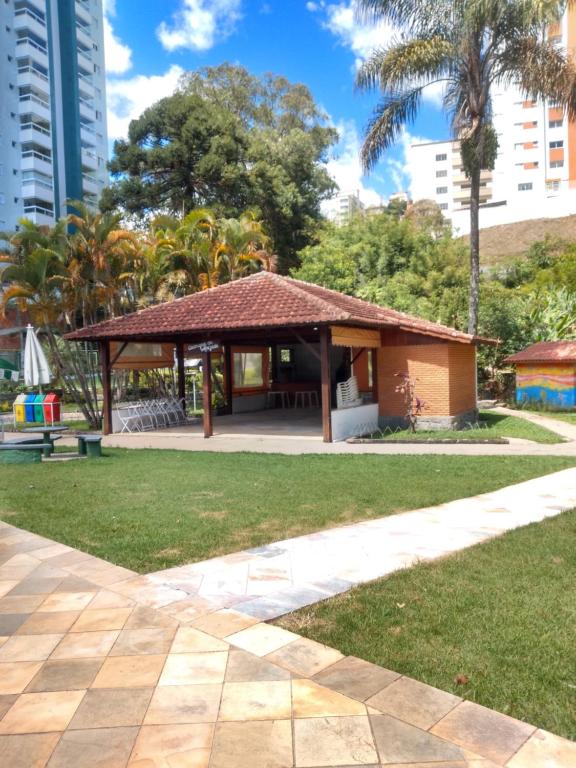 un pavillon dans un parc avec des palmiers et des bâtiments dans l'établissement Condomínio Resort na cidade das águas sulfurosas, à Poços de Caldas