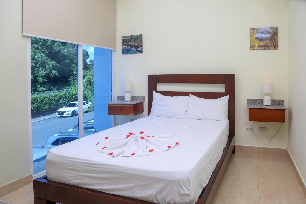 a bedroom with a bed with red bows on it at Anton Reef in Sosúa