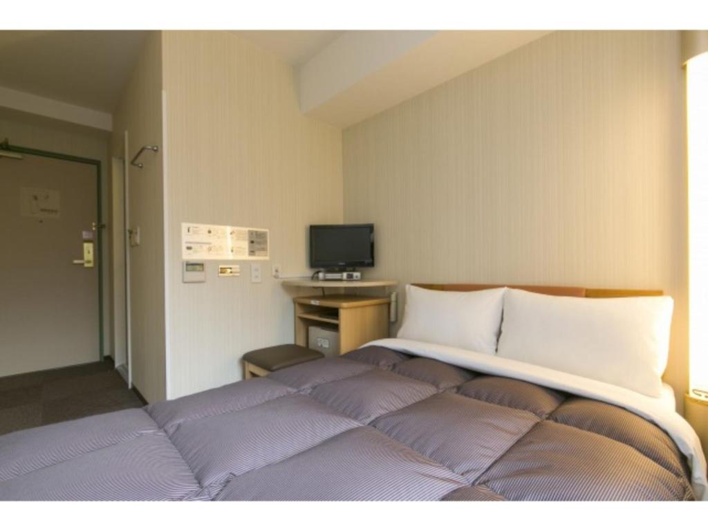 盛岡市にあるR&B HOTEL MORIOKA EKIMAE - Vacation STAY 13859vの紫色の枕が付いた大きなベッドのある寝室