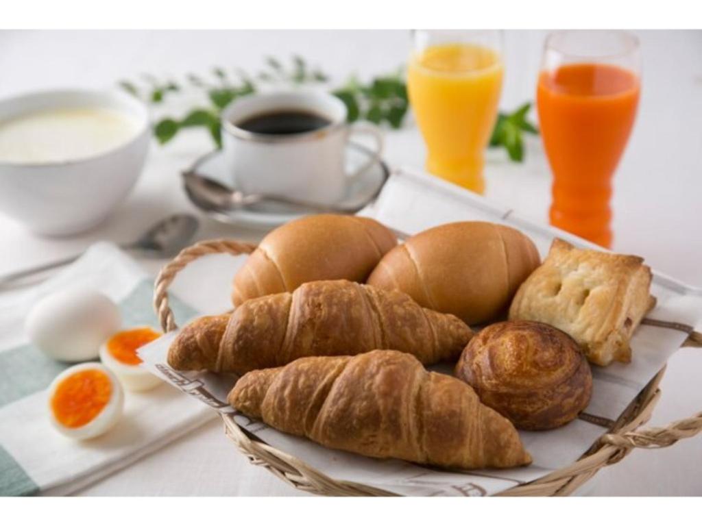 ein Teller Brot und Croissants auf dem Tisch in der Unterkunft R&B HOTEL NAGOYA SAKAE HIGASHI - Vacation STAY 14033v in Nagoya