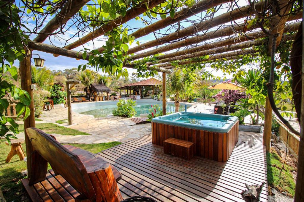 a hot tub on a deck with a pergola at Pousada Vereda da Serra in Pirenópolis